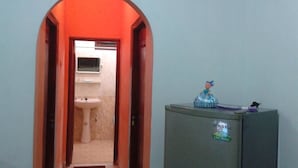 Un pasillo estrecho con un lavabo y un refrigerador.