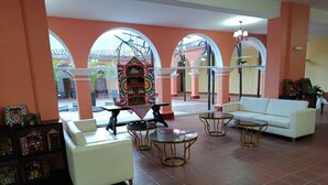 Un vestíbulo con un sofá blanco, una mesa de centro y un aparador decorativo.