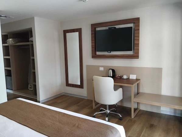 A hotel room with a bed, a desk, a chair, a television, and a wardrobe. - DM Hoteles Ayacucho (Ayacucho)