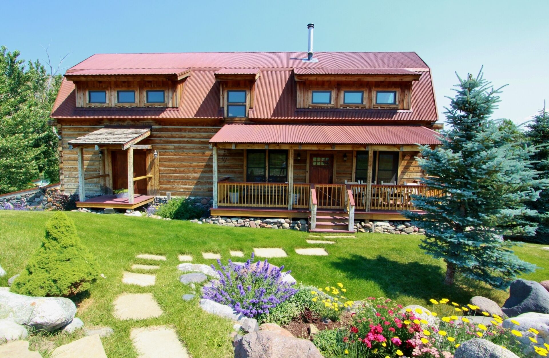 Flowers and green grass surround the home in late spring through the summer.