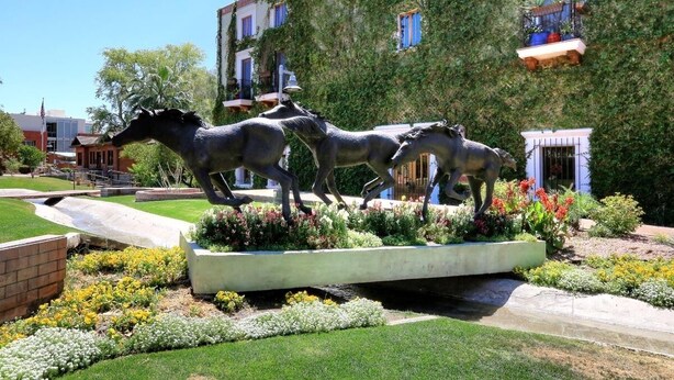 A garden with a horse statue, surrounded by well-maintained flower beds and a paved walkway. - Golf & Baseball Batting Cage/ Hot Tub/ Luxurious Living/ Private, Gated, Quiet (Scottsdale)