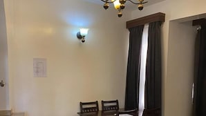 Ein Essbereich mit Tisch und Stühlen, einer Chandelieber und einer Wandleuchte.