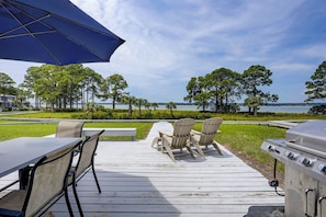 A deck with outdoor furniture, a grill, and a view of the water. - Beautiful Lands End Townhome with Spectacular Water Views & Close to Beach (Hilton Head Island)