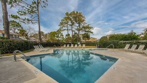 A rectangular swimming pool with a concrete deck, surrounded by lounge chairs and trees. - Beautiful Lands End Townhome with Spectacular Water Views & Close to Beach (Hilton Head Island)