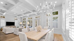 A spacious room with a large wooden dining table, white upholstered chairs, and a modern chandelier. - WaterColor Luxury on 30A! 63 Western Lake, Park District, Pool, 7 Bdrms, Slps 16+ (Santa Rosa Beach)