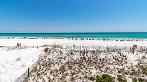 A beach with a sandy area and a wooden fence.