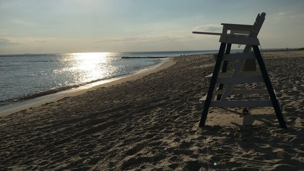 Une plage avec un poste de surveillance pour les sauveteurs et une vue dégagée sur l’océan.