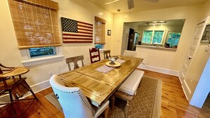 Une salle à manger avec une table en bois, des chaises et un ventilateur de plafond.