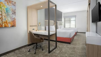 A hotel room with a bed, a desk, a chair, a TV, and a painting on the wall.