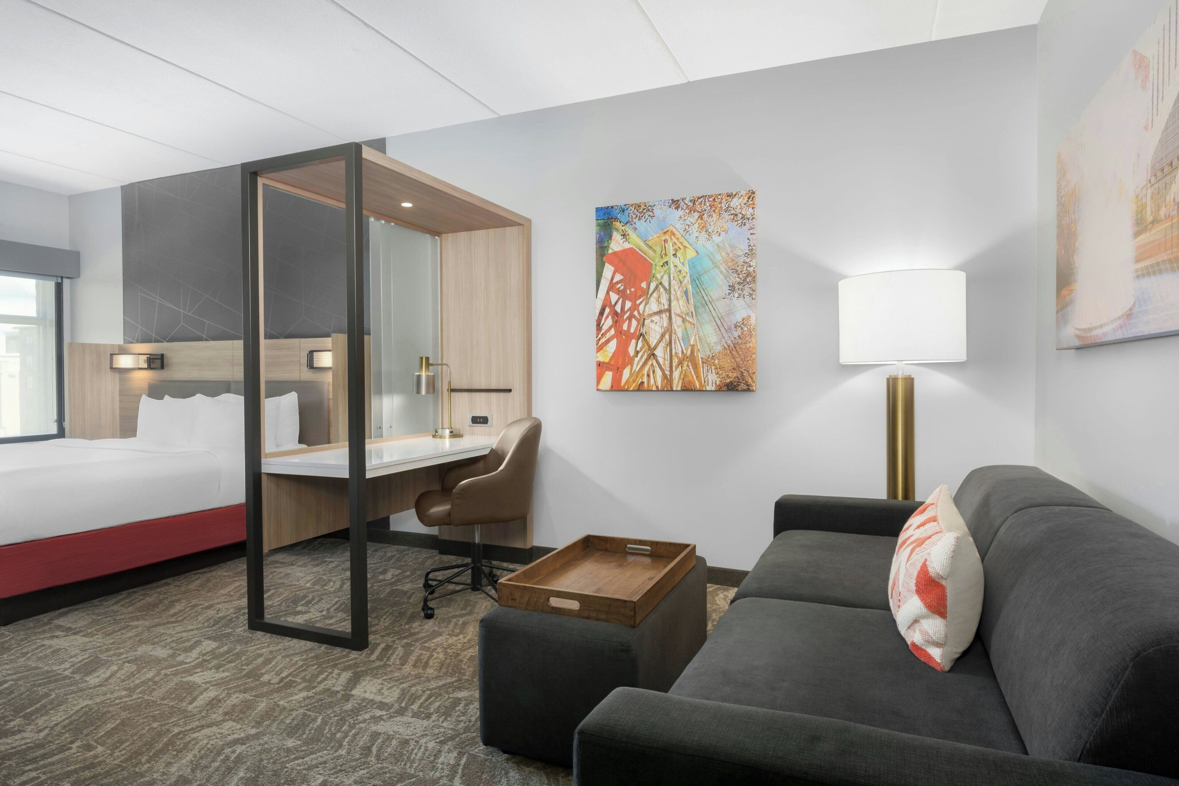 Ein Hotelzimmer mit Bett, Schreibtisch, Stuhl und einer Couch.
