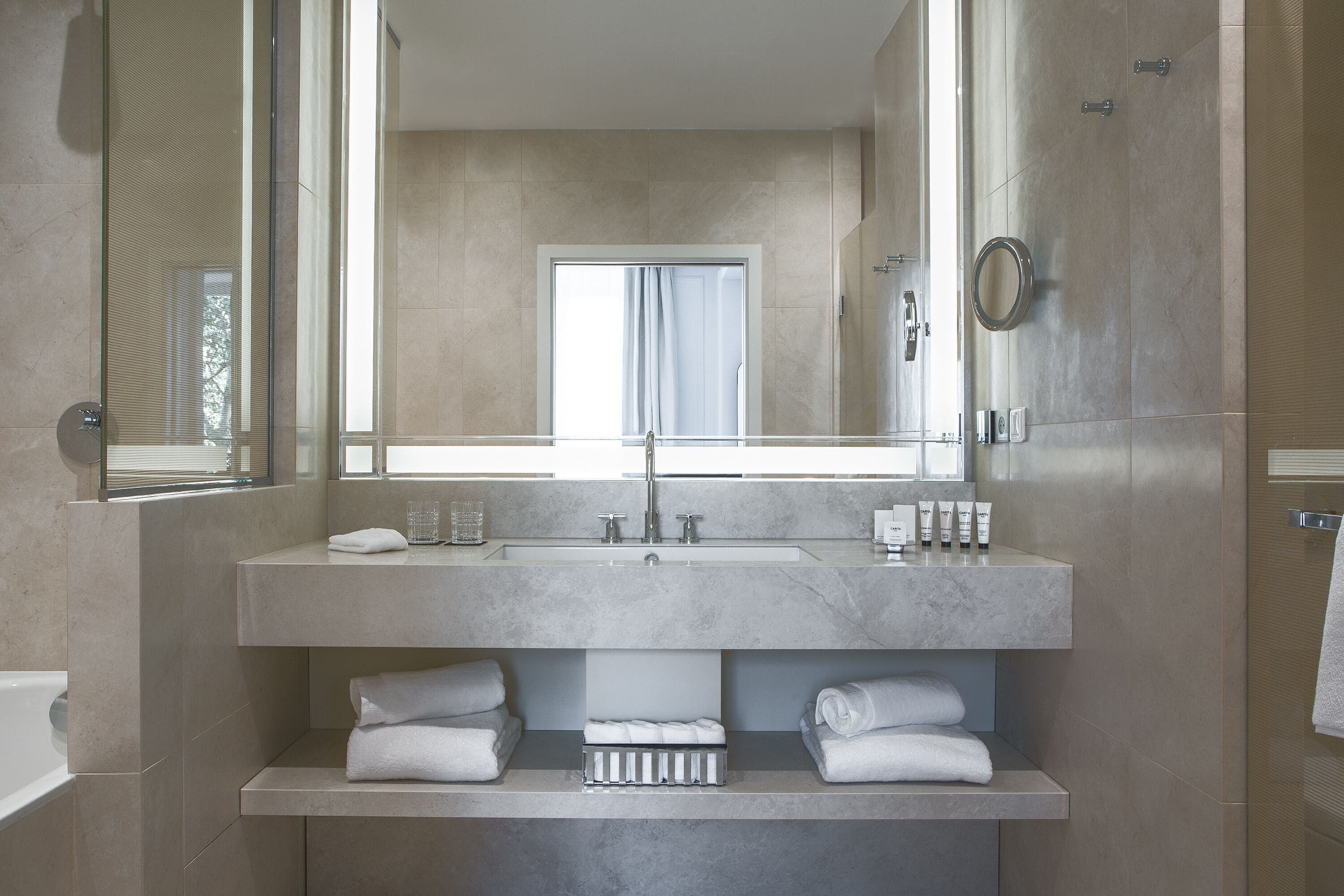 Un bagno moderno con uno specchio grande, un lavandino e una doccia.