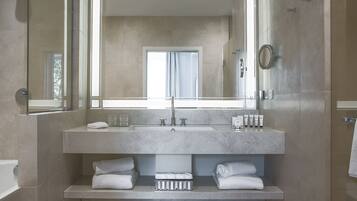 Un bagno moderno con uno specchio grande, un lavandino e una doccia.