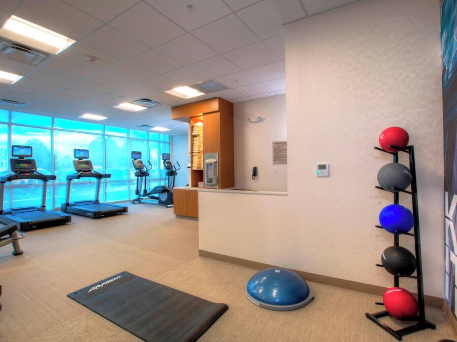 Ein Fitnessstudio mit Laufbändern, Gymbällen und einem großen Fenster mit Blick.