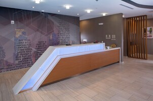 Un mostrador de recepción con diseño moderno, una pared con texto y una partición de madera.