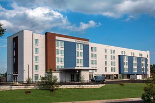 Un hotel moderno con techo plano, ventanas amplias y un cartel que dice "Springhill Suites Marriott".