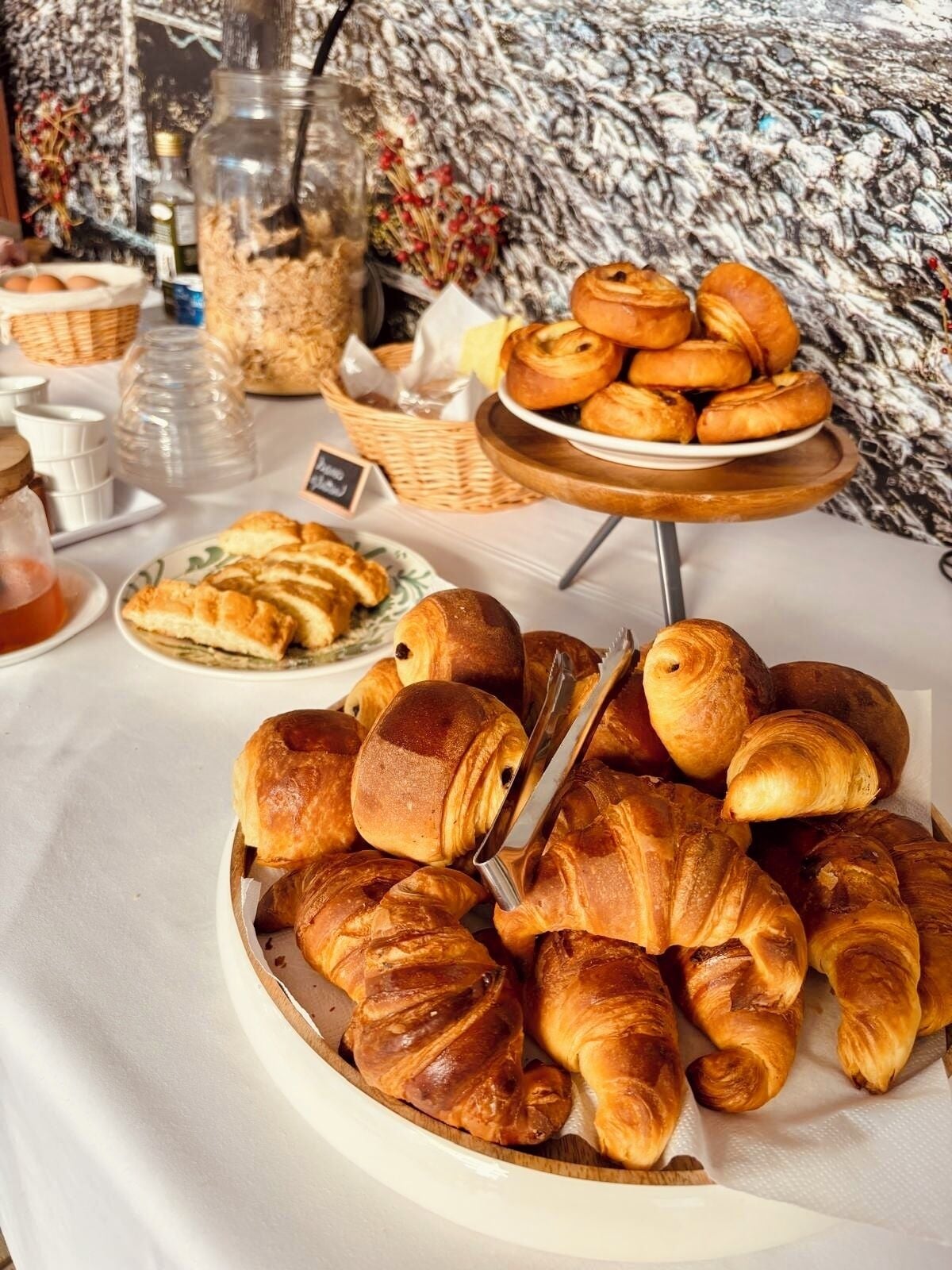 A buffet table with various baked goods including croissants and pastries.