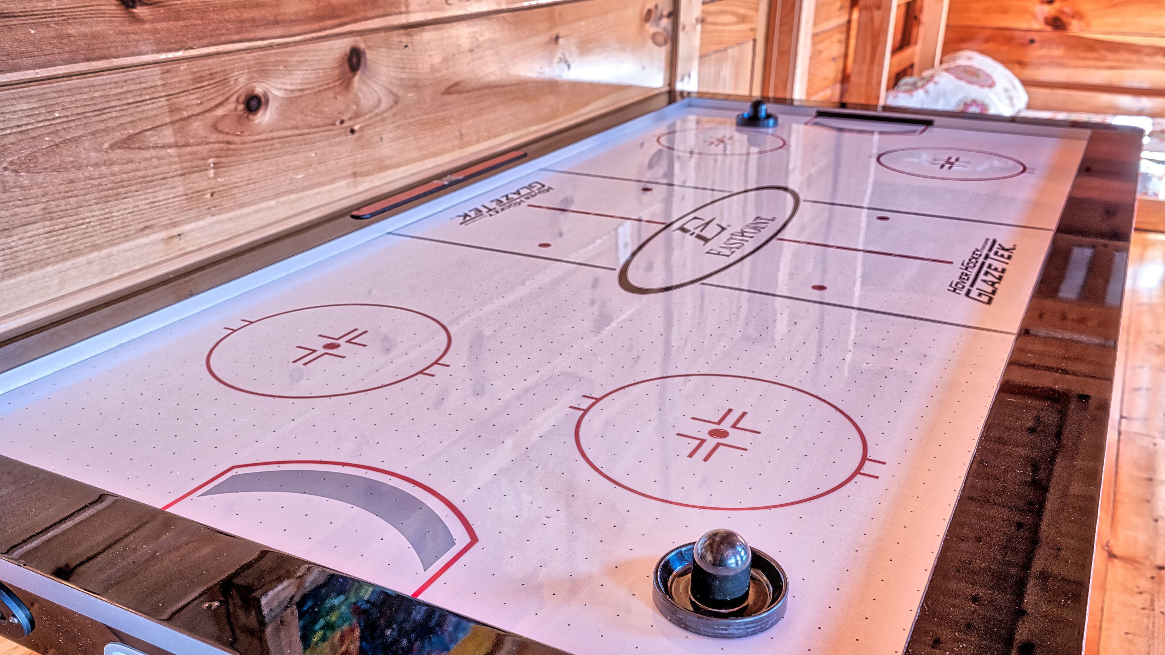Una mesa de shuffleboard con marcas y un disco.