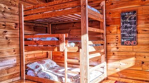 A wooden cabin interior with a loft bed and a motivational quote on the wall.
