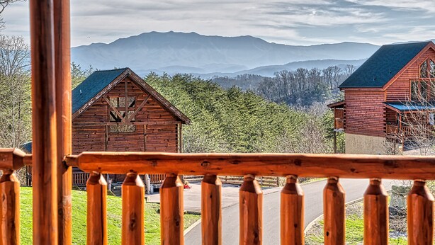 Una cabaña de madera con el paisaje de una montaña al fondo.