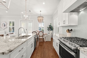 Enjoy cooking in this well-equipped kitchen with a central island, stove, and stainless steel sink.
