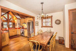 A kitchen with wooden cabinets, a dining table, and chairs. - Rockwood by Hauserman Rentals (Carnelian Bay)