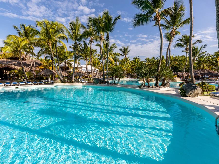 Een buitenzwembad, parasols bij het zwembad en ligstoelen