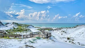 A beach with a wooden boardwalk leading to a sandy area with sparse vegetation. - Gulf Front Penthouse Condo * Complimentary LSV 407 Compass Point 1, WaterSound - 3 BR, SLPS 8 (Panama City Beach)