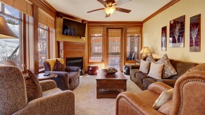 A cozy living room with leather sofas, a wooden coffee table, and a fireplace.