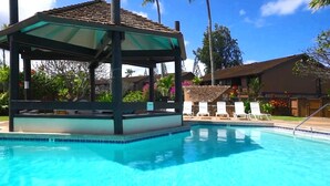 A swimming pool with lounge chairs and a covered pavilion.