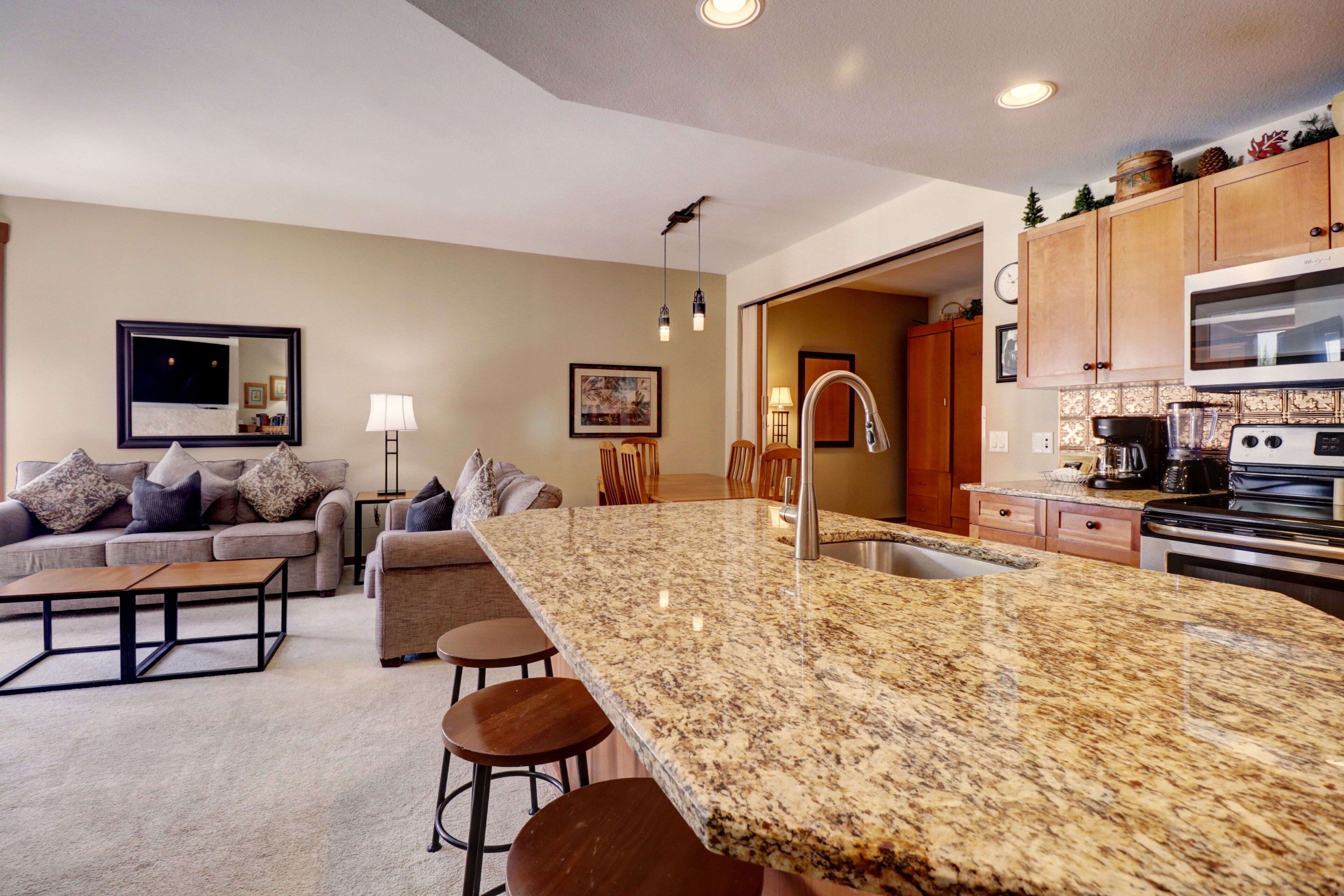 A modern kitchen with granite countertops, stainless steel appliances, and wooden cabinets.