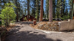 Une cabane située dans une forêt, avec une allée pavée et des murs en pierre.