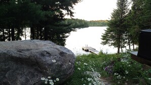 A large rock with daisies in a garden by a lake. - Beautiful lakefront cottage, 1 hour north of Montreal (Wentworth)