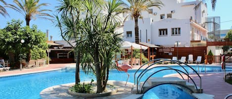 Una piscina al aire libre de temporada, tumbonas