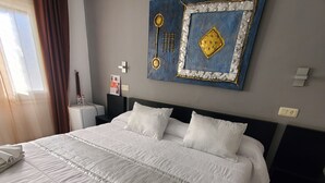 A neatly made bed with white linens, a towel, and a bottle of lotion. - Hotel Ampuria Inn (Castello d'Empuries)