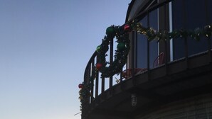 A building with a balcony decorated with greenery and red ornaments, large windows, and a grassy area in the foreground. - Country get away in Waxahachie, TX on 10 acres Shared with The Yurt in the Woods (Waxahachie)