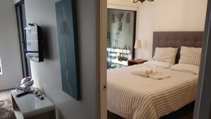A bedroom with a bed, bedside table, lamp, and a wall-mounted TV. - Central Santiago (Santiago)