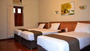 A hotel room with two beds, a wooden headboard, a painting on the wall, and a window with curtains. - DM Hoteles Mossone Ica (Ica)
