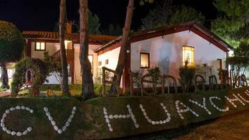 A house with a well-lit exterior and a stone pathway leading to the entrance.
