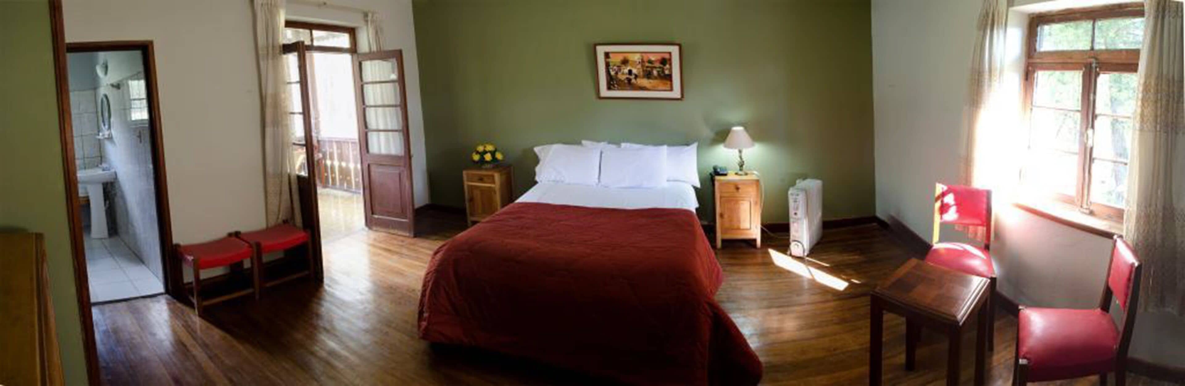 A room with a bed, a nightstand, a chair, and a window.