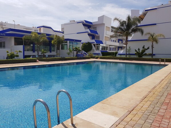 Alberca al aire libre, sombrillas en la alberca y camastros 