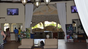 A lobby with a stone archway, a bar area, and a seating area with a view of the outdoors.