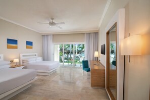 Une chambre d’hôtel avec deux lits, un bureau, une chaise, une télévision et un balcon donnant sur l’extérieur.