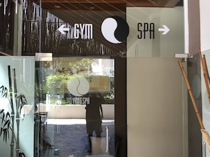 L’entrée d’un immeuble, avec une enseigne indiquant la présence d’une salle de sport et d’un spa.