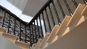 A staircase with a stone wall and a small window at the top. - The Portree Hotel (Portree)