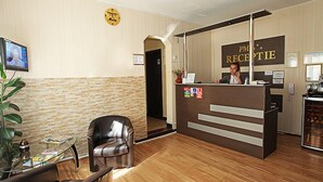 A reception area with a receptionist desk, a clock, a TV, and a reception sign. - Pension Mora Cluj Napoca (Cluj-Napoca)