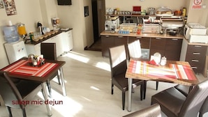 A modern kitchen with a dining area, equipped with a coffee machine, toaster, and a water dispenser. - Pension Mora Cluj Napoca (Cluj-Napoca)