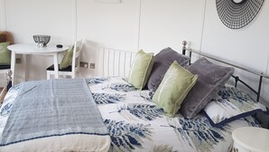 A bedroom with a bed, bedside tables, and a mirror. - Skye Cabins (Skeabost)