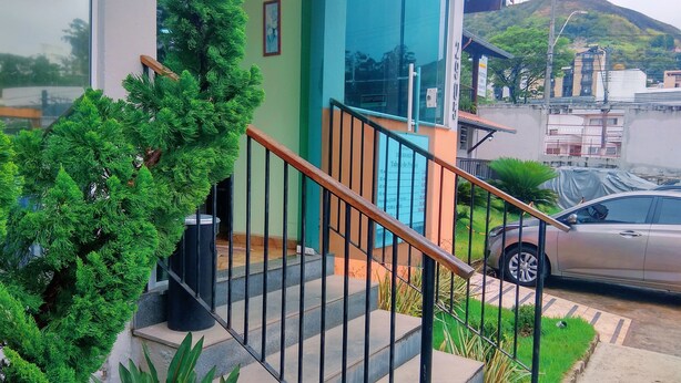 Un edificio moderno con una escalera, un automóvil estacionado y un césped verde.