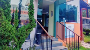 Un edificio moderno con entrada de cristal, una escalera y un letrero que indica un cargo por estacionamiento.
