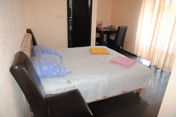 A bedroom with a bed, a chair, a desk, and a window with curtains. - Villa Dulsinea (Ulcinj)